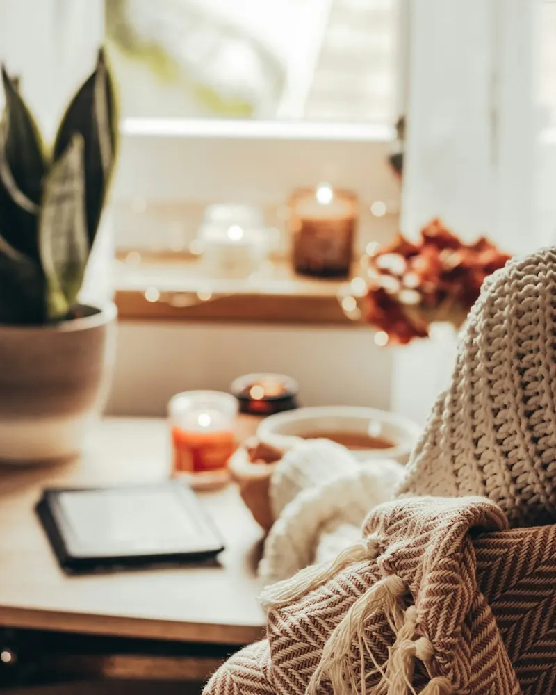 Cozy self-care moment with a knit sweater, a warm drink and candles